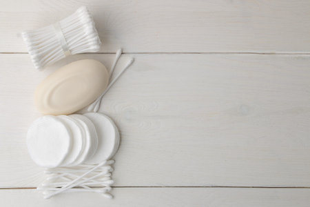 Various personal care products. Cotton pads and sticks, soap, towel on a white background. top view....