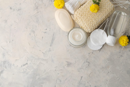 Various personal care products. Face cream, Soap, Cotton pads, washcloth, sticks and yellow flowers...