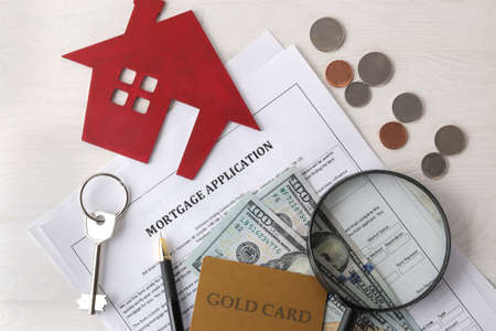 Home purchase concept. Small decorative house keys, contract and money on a white background. top viewの写真素材