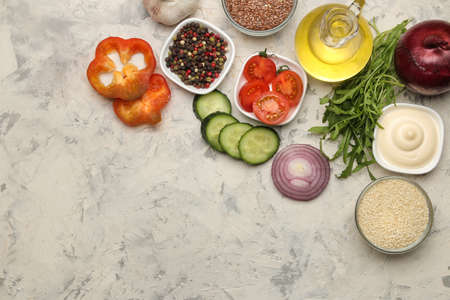 Set of sliced vegetables and spices for the preparation of salads or other dishes on a light table. ingredients for cooking. top viewの写真素材