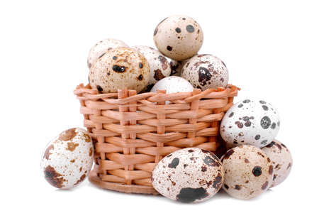 A lot of quail eggs in a small wicker basket. on a white background. isolatedの写真素材