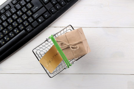 The concept of online shopping. Composition with discount cards in a shopping basket on a light...