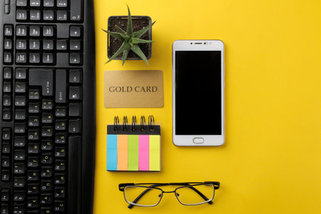 The concept of online shopping. Composition with a discount card and phone on a yellow background