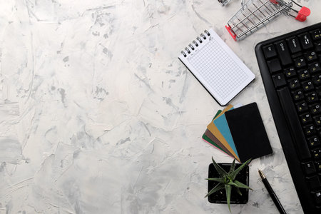 The concept of online shopping. Composition with discount cards and shopping trolley and telephone on a light background.の写真素材