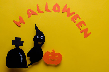 The concept of the holiday of Halloween. Bring and pumpkin with an inscription of Halloween on a yellow background. top viewの写真素材
