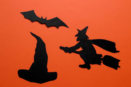 The concept of the holiday of Halloween. witch and bat on orange background. top viewの写真素材