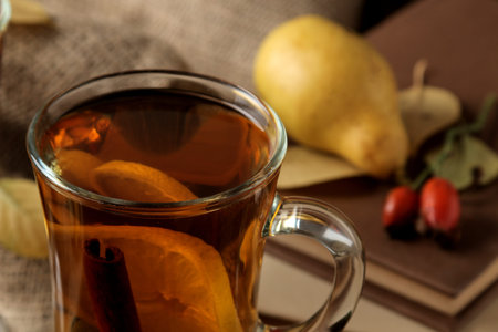 Autumn composition with hot tea and dried apricots on a brown wooden table with a place for...