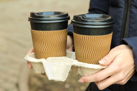 The girl holds paper cups for hot drinks in her hands. coffee to goの写真素材