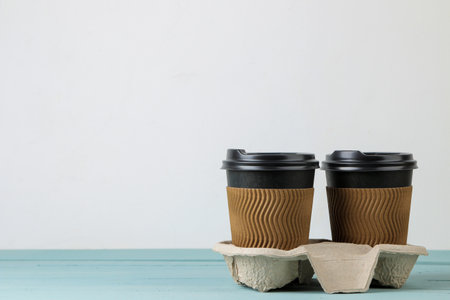 Paper cups with coffee on a blue table. coffee to goの写真素材