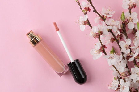 Flowering branch. Spring flowers and lipgloss on a bright pink background. top view.の写真素材