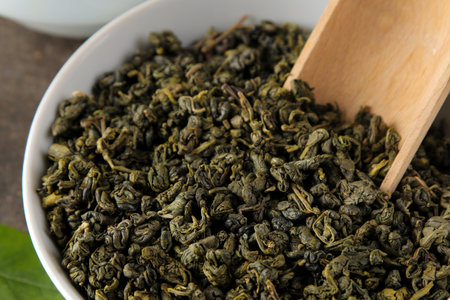 green tea. Dry tea leaves in a bowl with a spoon.の写真素材