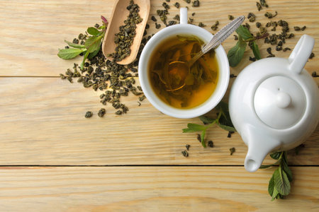 Teapot and hot green tea in a cup on a wooden background. top viewの写真素材