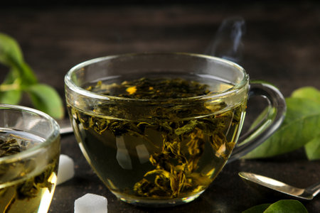 green tea. Hot tea in a cup, sugar and mint on a dark background.の写真素材