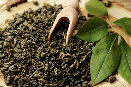 green tea. Dry leaves tea and spoon close-up on a wooden background.の写真素材