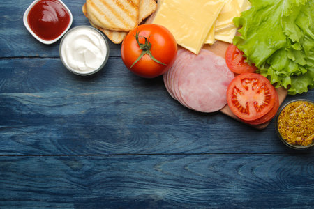 Sandwich. Ingredients for making sandwiches ham, cheese, tomato on a blue backgroundの写真素材