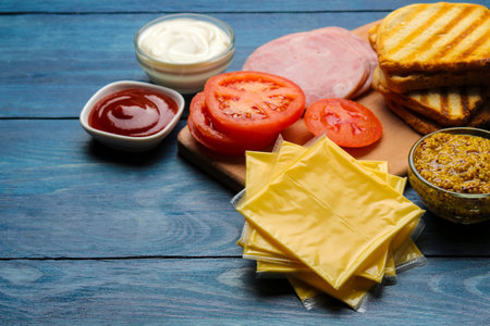 Sandwich. Ingredients for making sandwiches ham, cheese, tomato on a blue backgroundの写真素材
