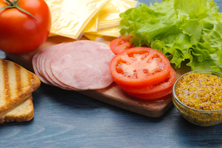 Sandwich. Ingredients for making sandwiches ham, cheese, tomato on a blue backgroundの写真素材