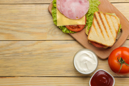 Sandwich with ham cheese and tomato on a wooden background. top viewの写真素材