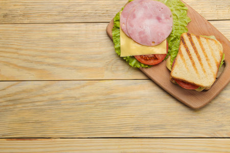 Sandwich with ham cheese and tomato on a wooden background. top viewの写真素材