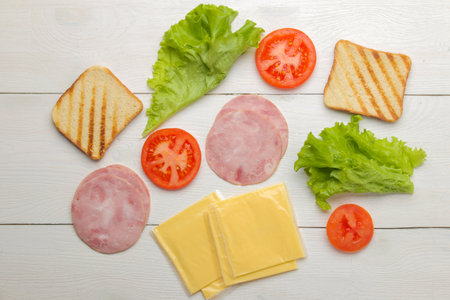 Sandwich. Ingredients for making sandwiches bread, ham, cheese, tomato on a white backgroundの写真素材