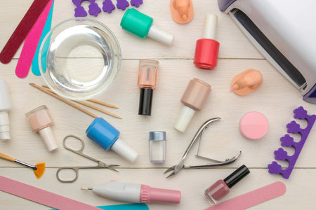 led lamp for nail extension and various gel polishes on a light background. view from above. tools for manicure and pedicure.の写真素材