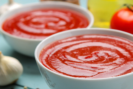 Tomato soup close-up and ingredients for cooking, tomatoes and garlic.の写真素材