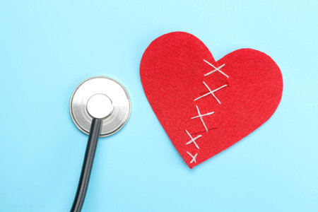 Stethoscope and red heart on a blue background. top view and free space. Cardiology and treatment of heart diseases.の写真素材