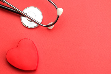 Stethoscope and red heart on a red background. top view and free space. heart health and medical care.の写真素材