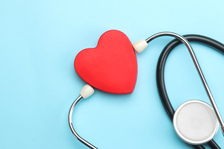 Stethoscope and red heart on a blue background. top view and free space. Cardiology and treatment of heart diseases.の写真素材