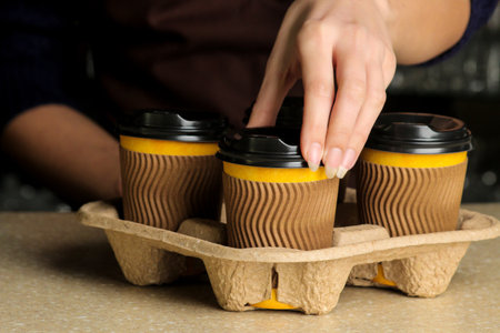 Barista girl holding paper cups for hot drinks. coffee to goの写真素材