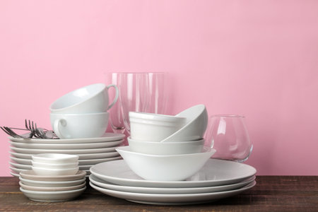 many different dishes. Dinnerware. on a pink background. utensils for table setting. various plates, bowls and cups.の写真素材