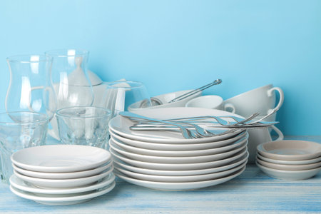 many different utensils. Tableware on a blue background. clean tableware. various plates, bowls and cups.の写真素材
