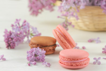 Macaron cake and a bouquet of lilacs on a light backgroundの写真素材