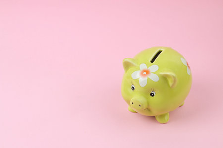 green pig piggy bank on pink background, money saving concept.の写真素材