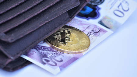 Bitcoin with twenty pounds note in the walletの写真素材