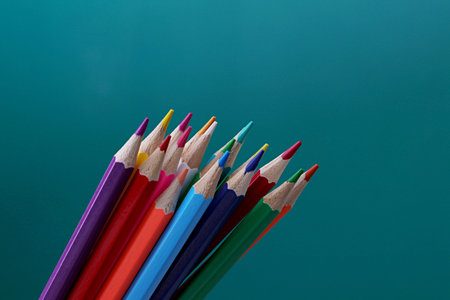 Sharp colored pencils on a green background