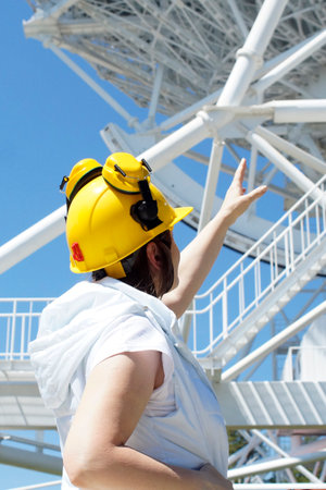 A young woman builder at a construction site in a helmetの写真素材
