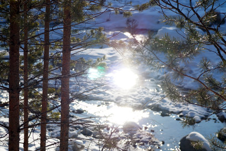 The bright sun is reflected in the mountain riverの写真素材
