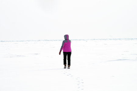 A woman walks on the endless ice of Lake Baikalの写真素材
