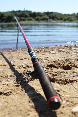 There is a fishing rod on the river, there are no people in the sand
