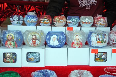 Glass multi-colored candlesticks with the image of the Virgin Mary and Jesus at the Christmas marketの写真素材