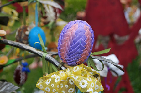 Decorative Easter eggs made of ribbons, threads and fabric at the Easter fair on a spring day