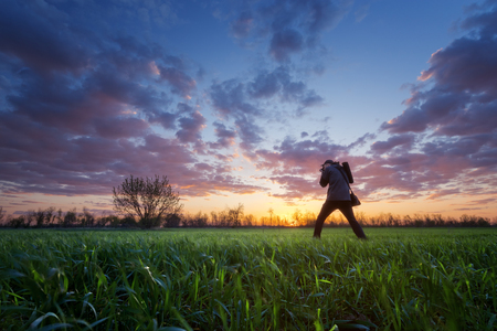 photographer on the field during sunset / hobby that brings pleasureの写真素材