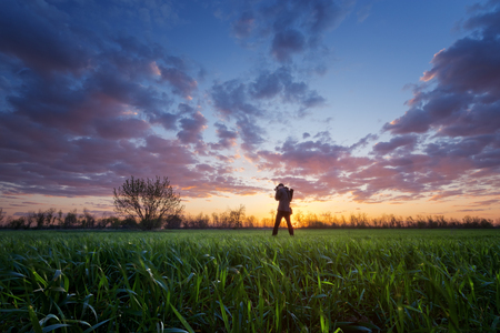 photographer on the field during sunset / hobby that brings pleasureの写真素材