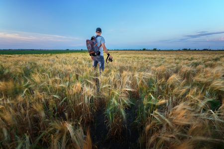 photographer while working search for a story / evening landscape man on the fieldの写真素材