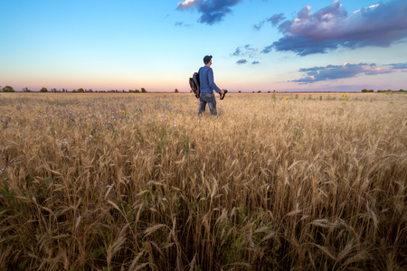 photographer while working search for a story / evening landscape man on the fieldの写真素材