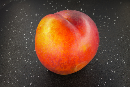 the ripe fruit is a bright peach / fruit of the peach on the black faneneの写真素材