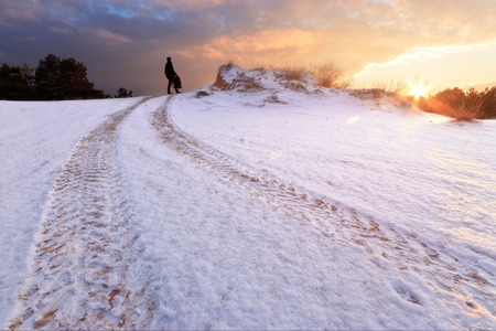 man standing on the trail / winter landscape off-road trackの写真素材