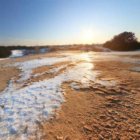 winter sunset sun on the horizon / sand desert snow lying on the sandの写真素材