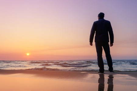 silhouette of a man at dawn / beach wilderness dawnの写真素材